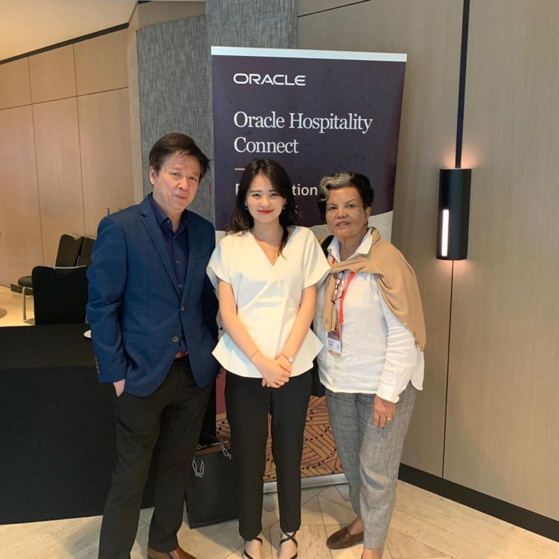 MDIS student posing for a picture with two professionals during a school visit to Oracle.